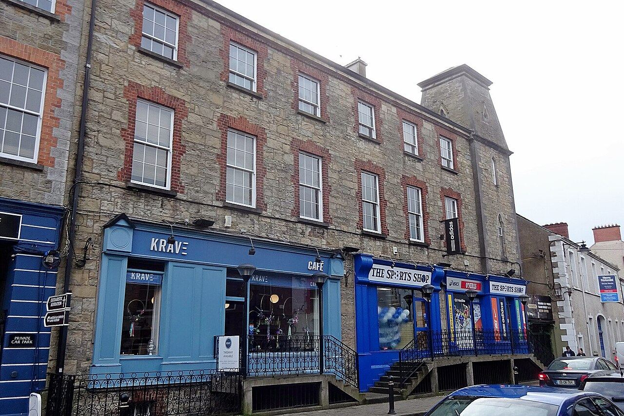 Main Street in Cavan with a four-storey stone building above a café and a sports shop