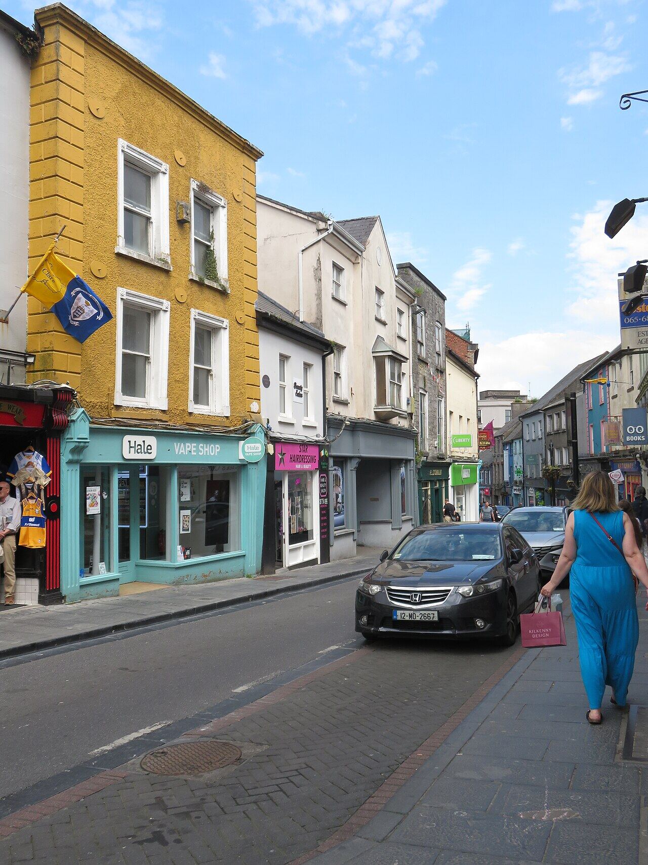 Abbey Street in Ennis with shopfronts and a pedestrian
