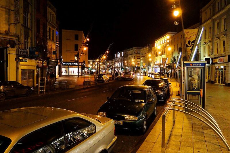 St Patrick Street, Cork, at night with parked cars under street lights