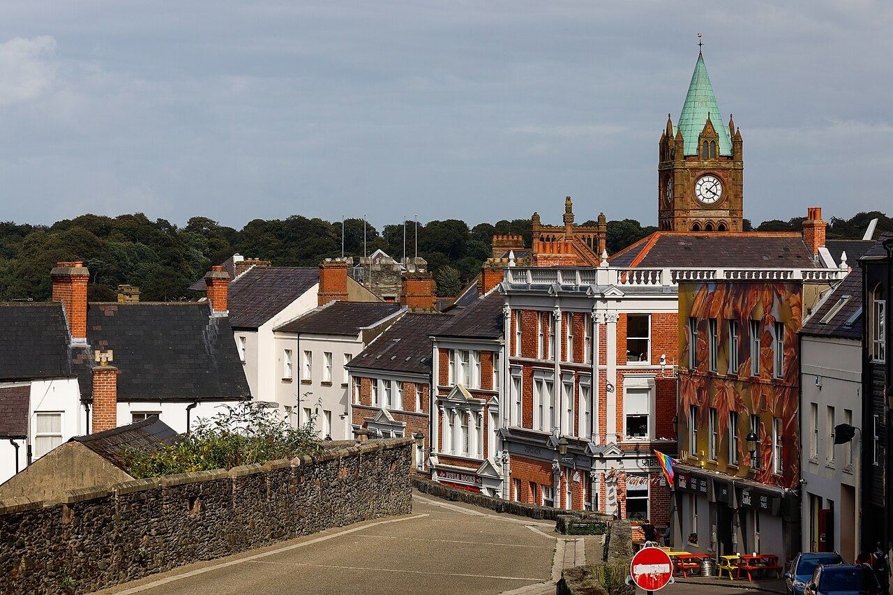 Magazine Street running inside the city walls, a row of brick and painted terraces with the Guildhall clock tower behind