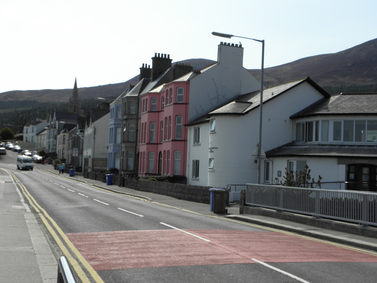 South Promenade in Newcastle with a terrace of painted houses and the Mourne Mountains behind