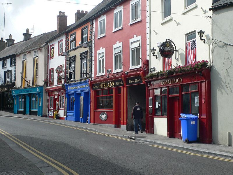 Row of painted pub and shop fronts on Parliament Street, including Phelan's