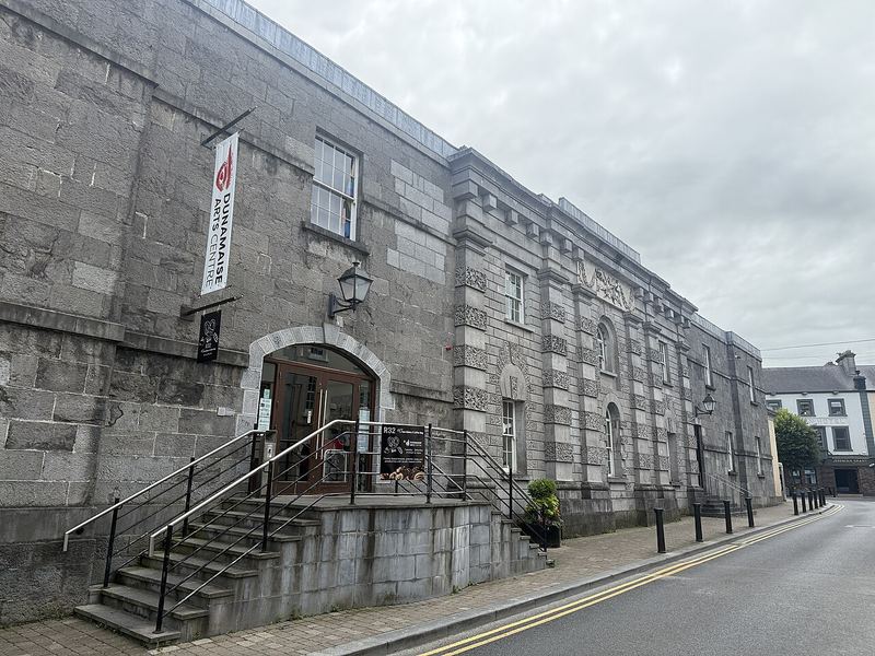 Grey stone front of the Dunamaise Arts Centre with steps and railings up to the entrance