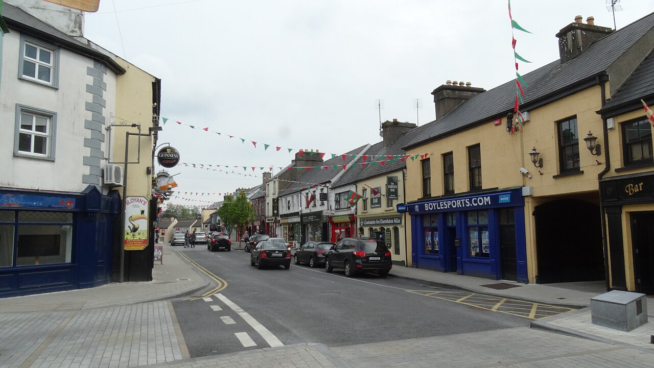 Linenhall Street in Castlebar with bunting across the road, shopfronts and parked cars