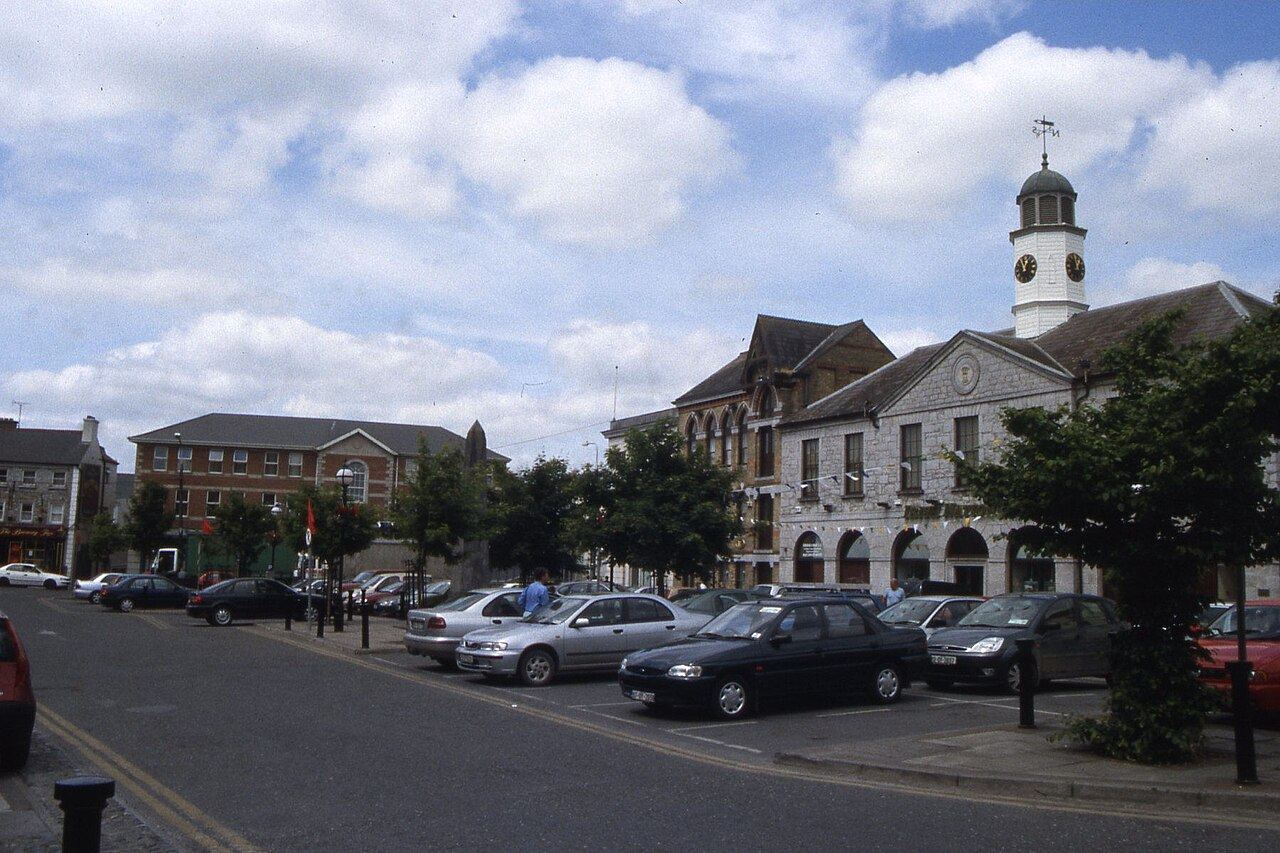 O'Connor Square in Tullamore on a bright day, parked cars in front of a building with a clock tower