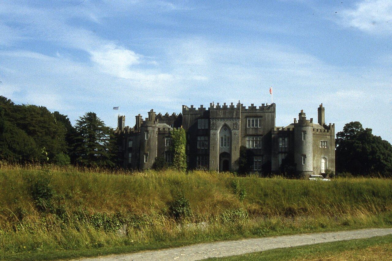 Birr Castle seen across long grass and a footpath in the demesne