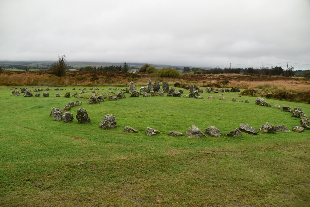 Ring of low standing stones in rough grass at Beaghmore, with moorland and bog under a grey sky