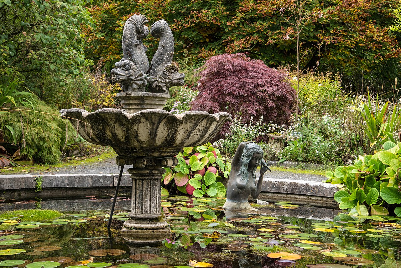 Stone fountain in a lily pond surrounded by shrubs in the Belvedere gardens