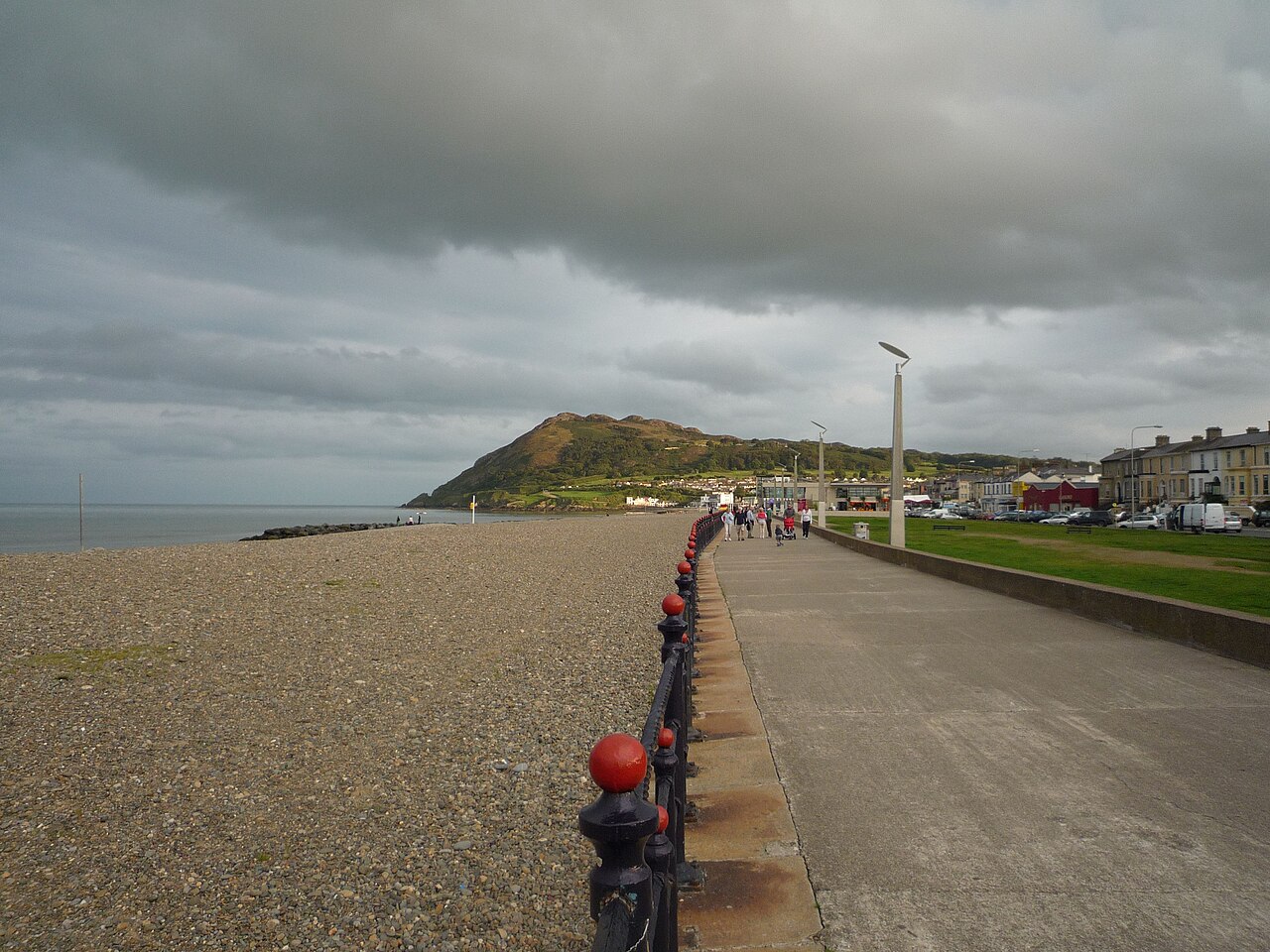 Bray promenade and shingle beach under grey cloud, with Bray Head behind