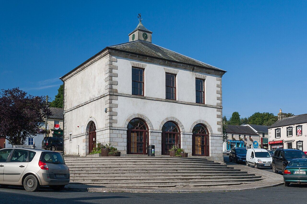 The white arched Market House on the square in Tinahely, with parked cars
